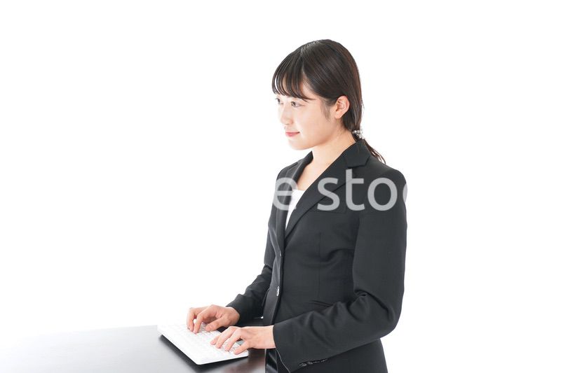 立ってデスクワークをする若いビジネスウーマン