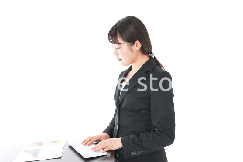 立ってデスクワークをする若いビジネスウーマン