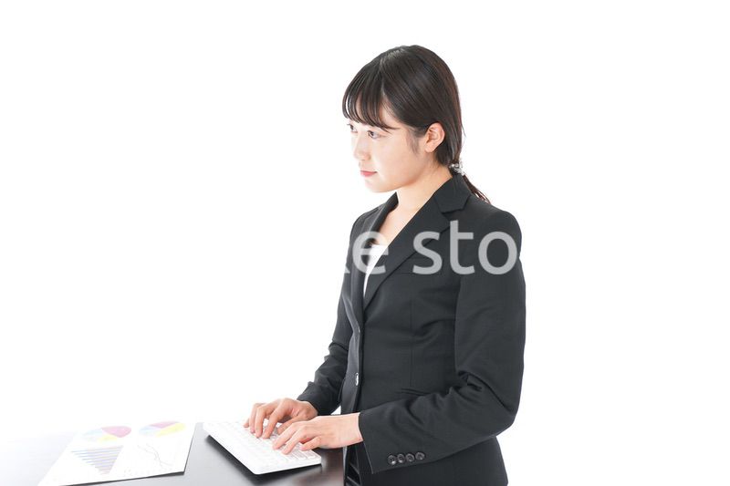 立ってデスクワークをする若いビジネスウーマン