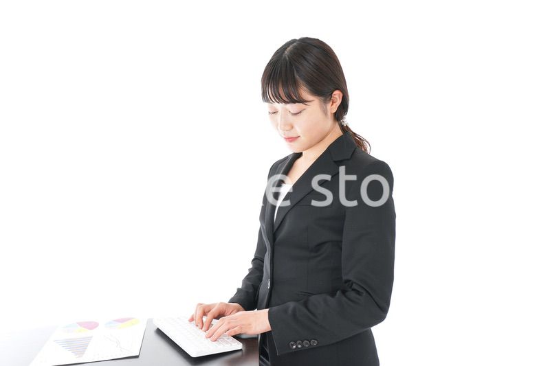 立ってデスクワークをする若いビジネスウーマン