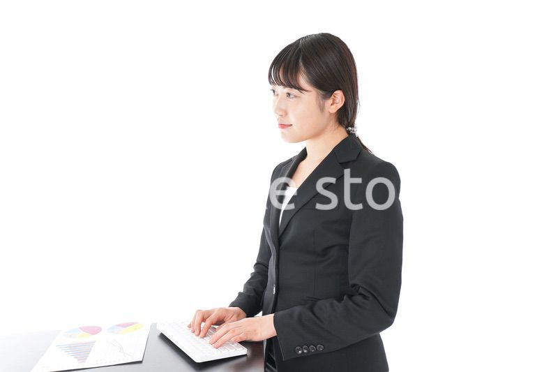 立ってデスクワークをする若いビジネスウーマン