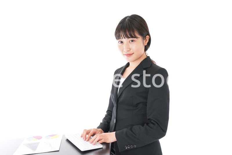 立ってデスクワークをする若いビジネスウーマン