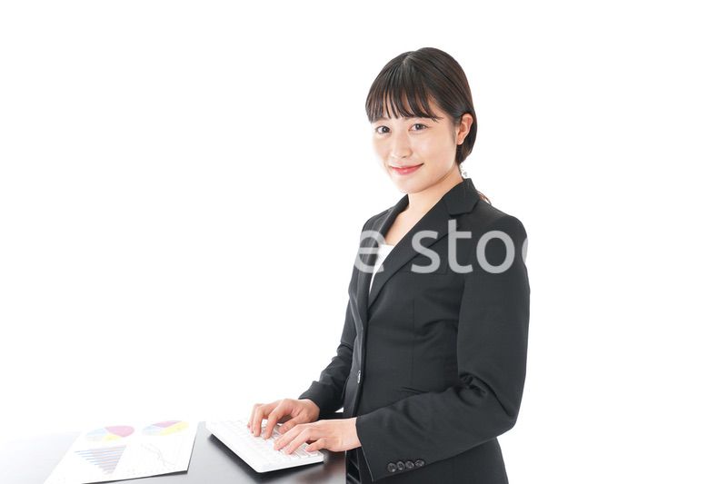 立ってデスクワークをする若いビジネスウーマン