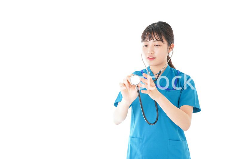 聴診器を使う笑顔の若いナース
