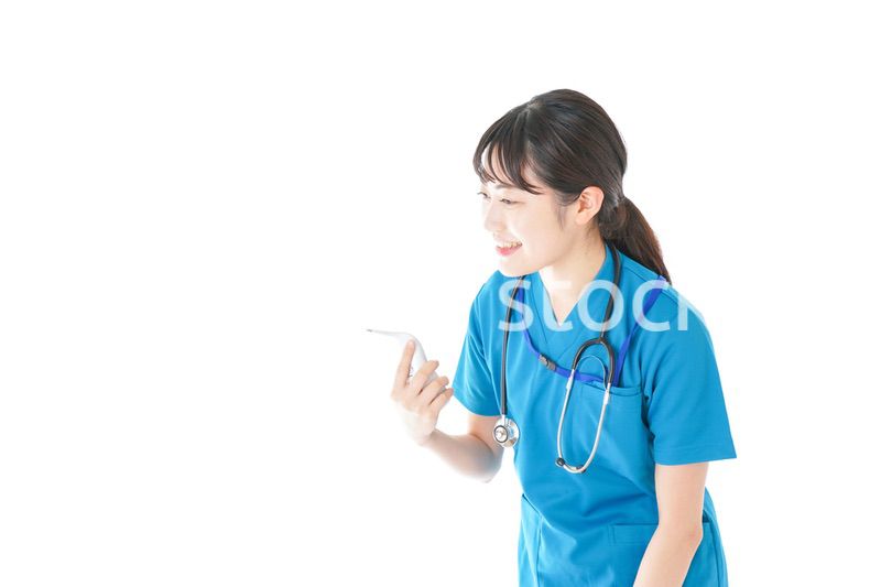 体温測定をする笑顔の若いナース