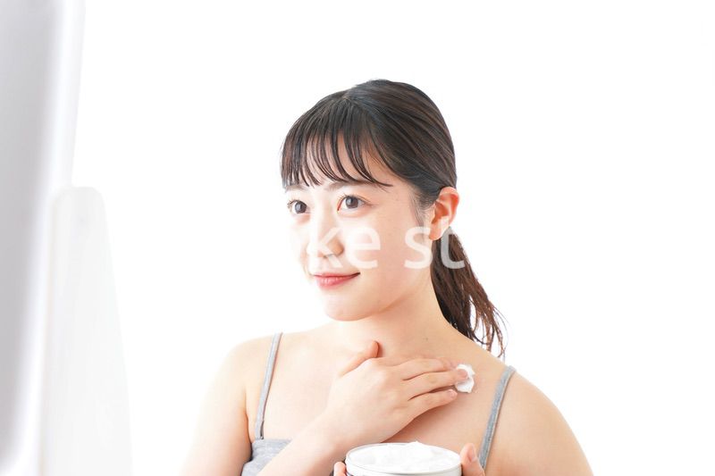 肌にクリームを塗る若い女性