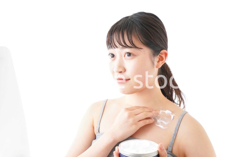 肌にクリームを塗る若い女性