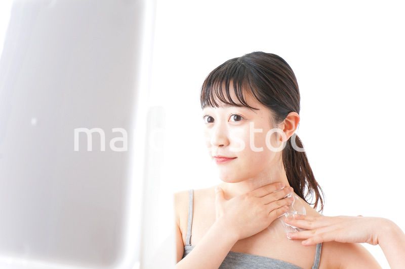 肌にクリームを塗る若い女性