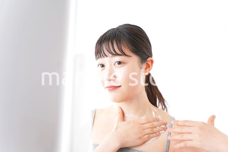 肌にクリームを塗る若い女性