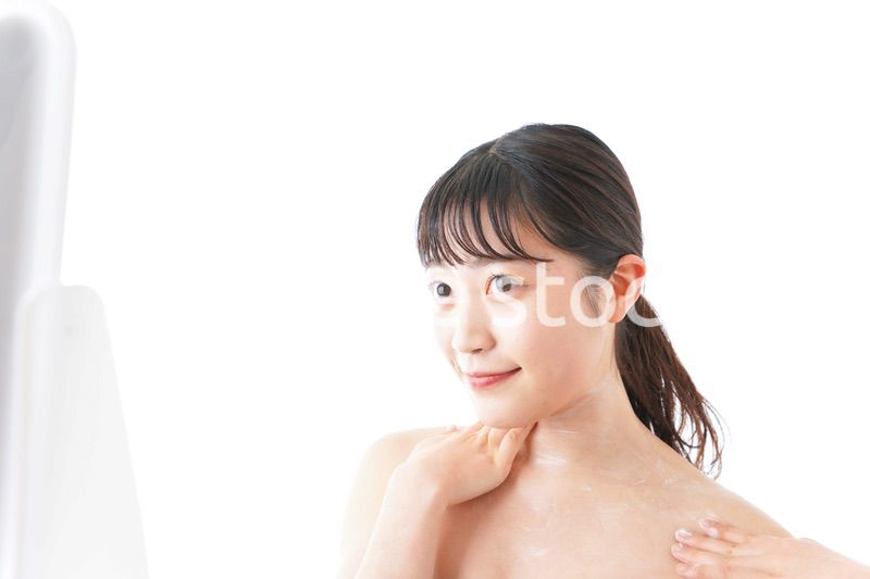 肌にクリームを塗る若い女性