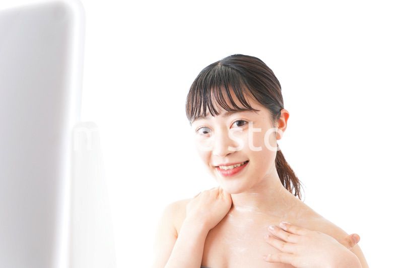 肌にクリームを塗る若い女性