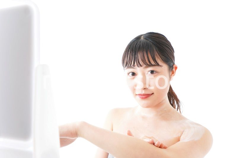 肌にクリームを塗る若い女性