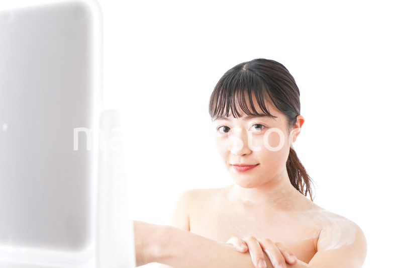 肌にクリームを塗る若い女性