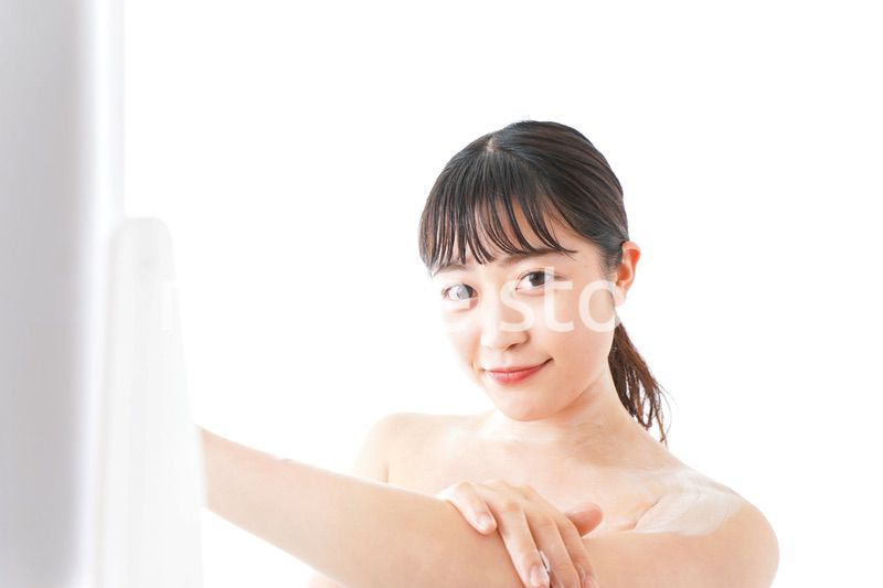 肌にクリームを塗る若い女性