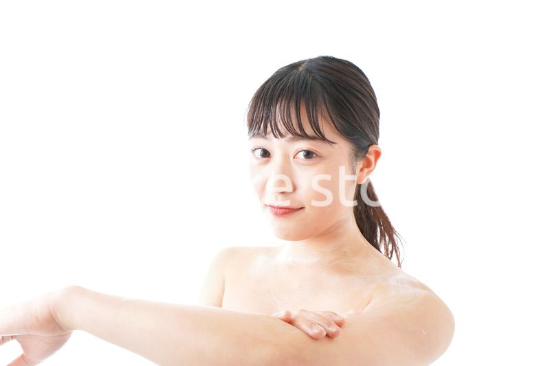 肌にクリームを塗る若い女性