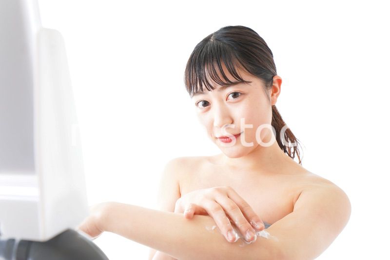 肌にクリームを塗る若い女性