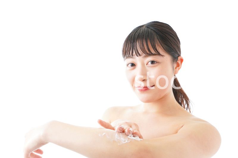 肌にクリームを塗る若い女性