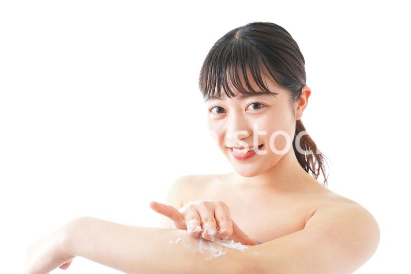 肌にクリームを塗る若い女性