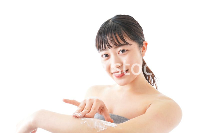 肌にクリームを塗る若い女性