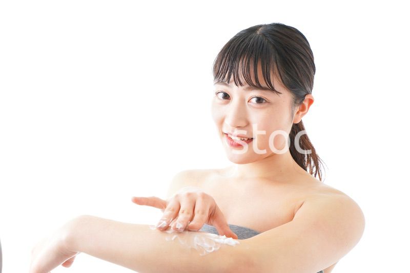 肌にクリームを塗る若い女性