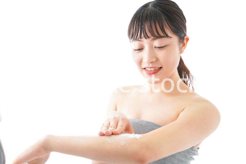 肌にクリームを塗る若い女性
