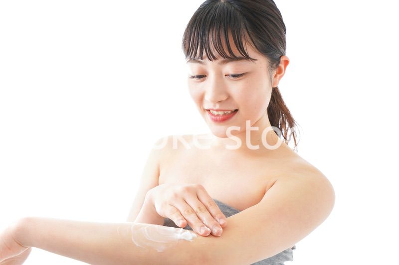 肌にクリームを塗る若い女性