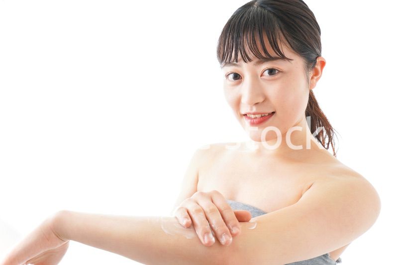 肌にクリームを塗る若い女性