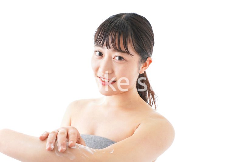 肌にクリームを塗る若い女性