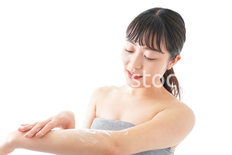 肌にクリームを塗る若い女性