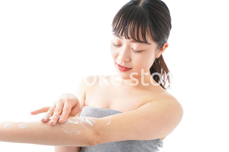 肌にクリームを塗る若い女性