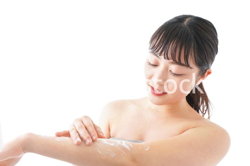 肌にクリームを塗る若い女性
