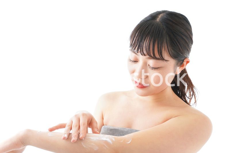 肌にクリームを塗る若い女性