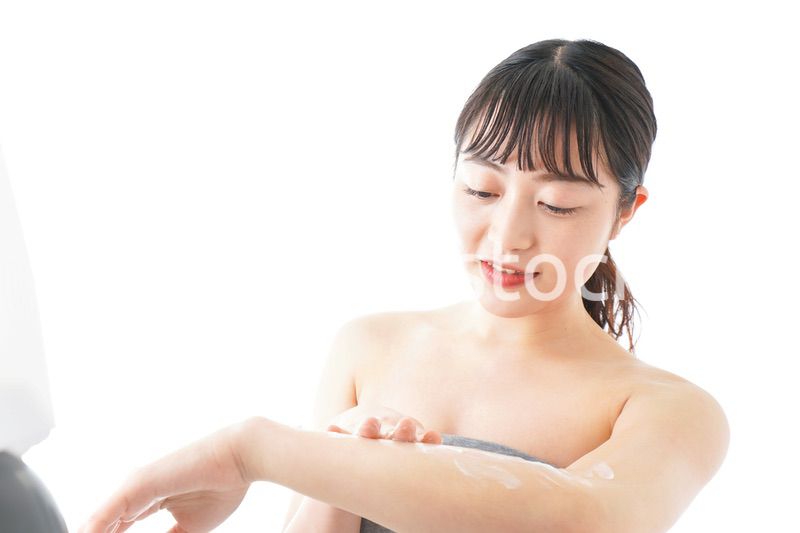 肌にクリームを塗る若い女性