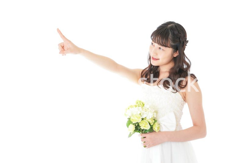 ブーケを持ち指差す花嫁の女性