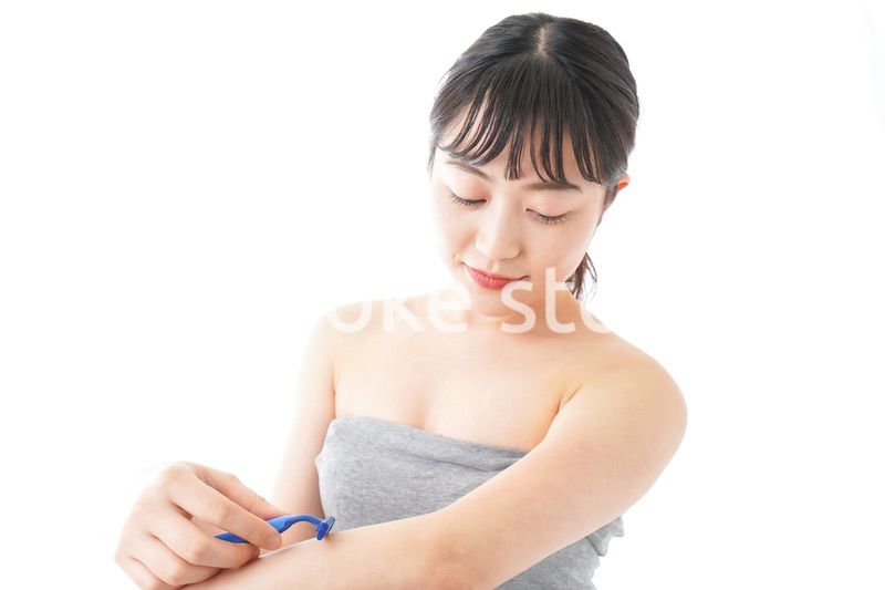 肌の脱毛をする若い女性