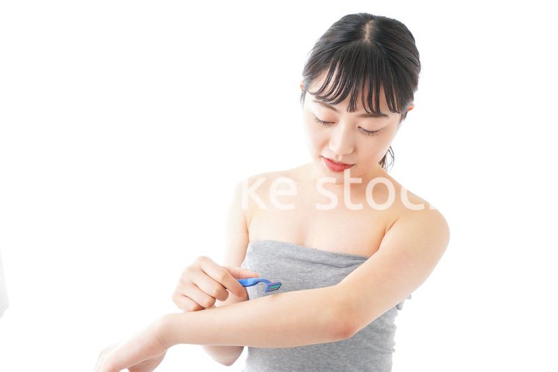 肌の脱毛をする若い女性