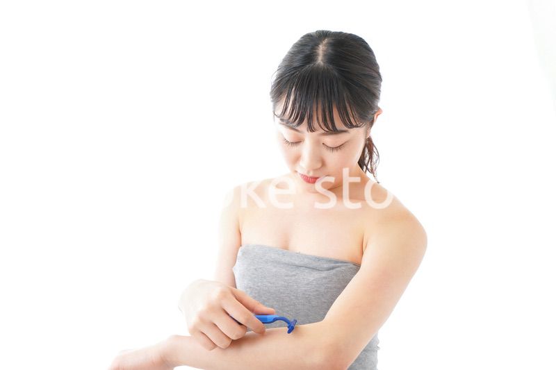 肌の脱毛をする若い女性