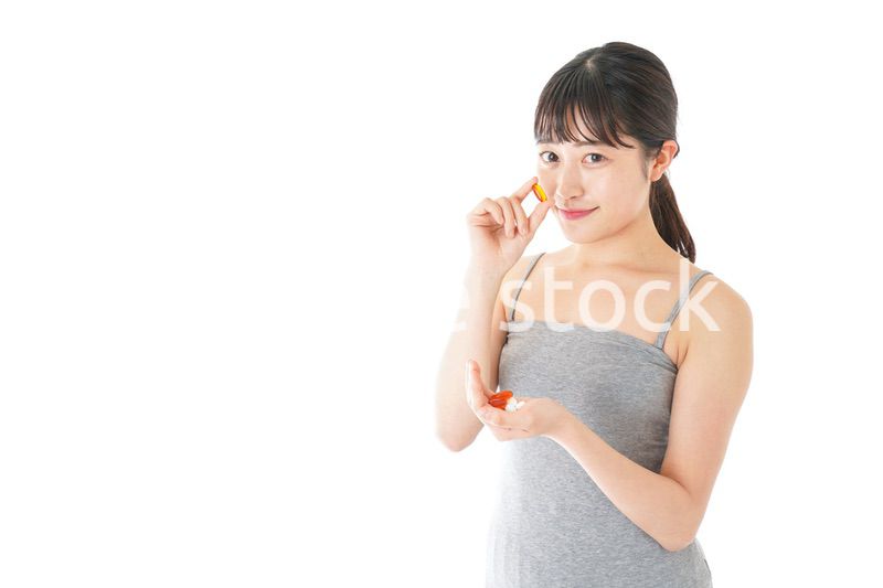 薬・サプリメントを服用する若い女性