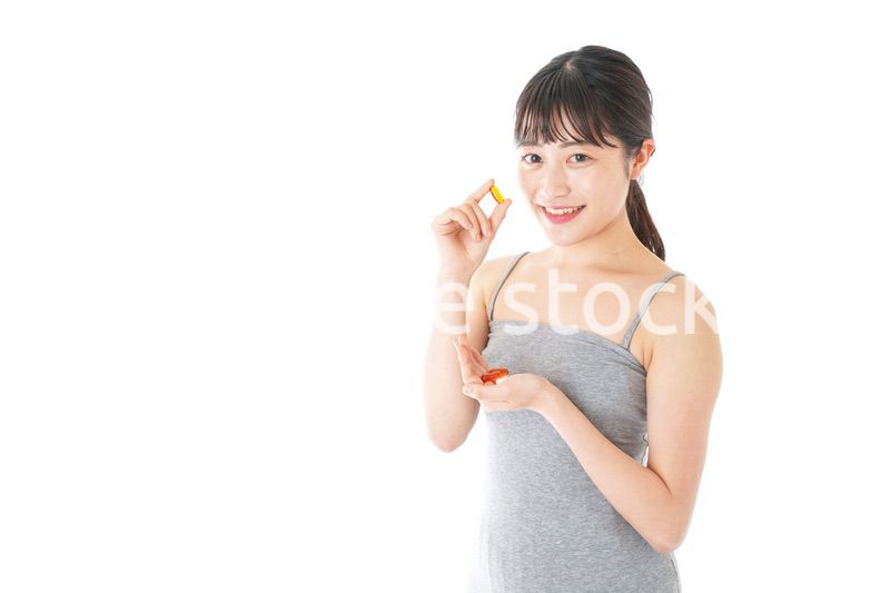 薬・サプリメントを服用する若い女性