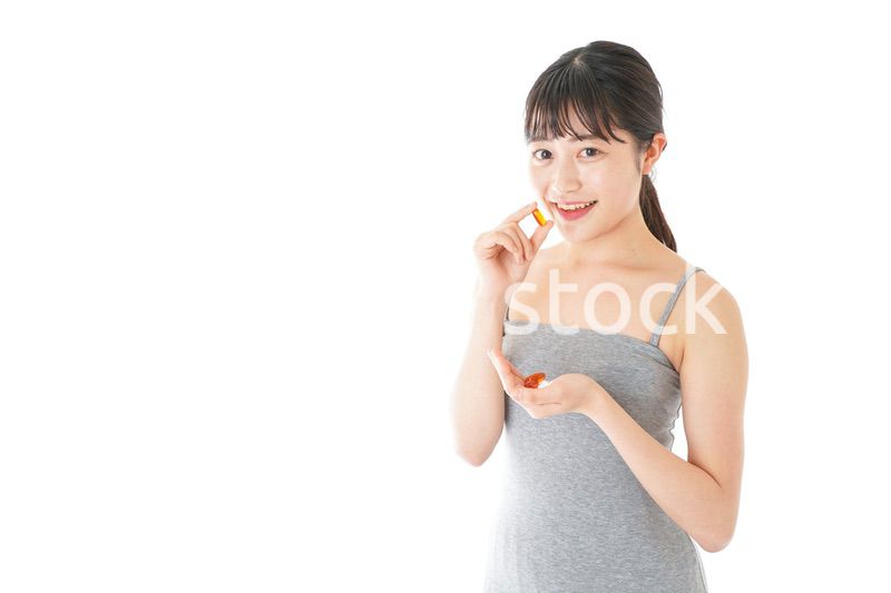 薬・サプリメントを服用する若い女性