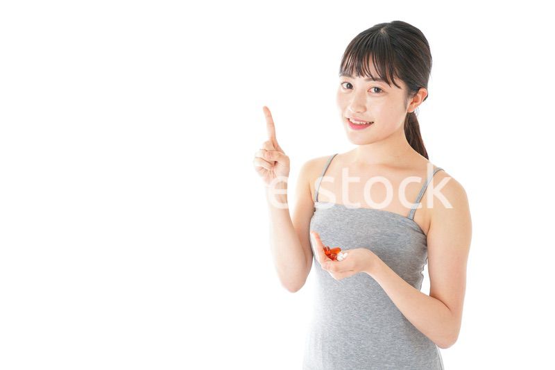 薬・サプリメントを服用する若い女性