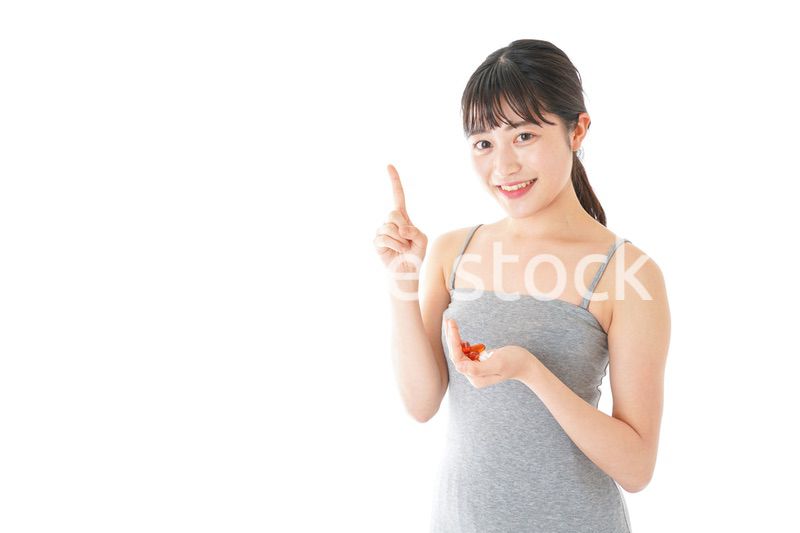 薬・サプリメントを服用する若い女性