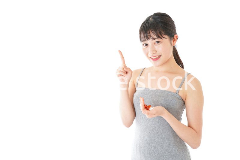 薬・サプリメントを服用する若い女性