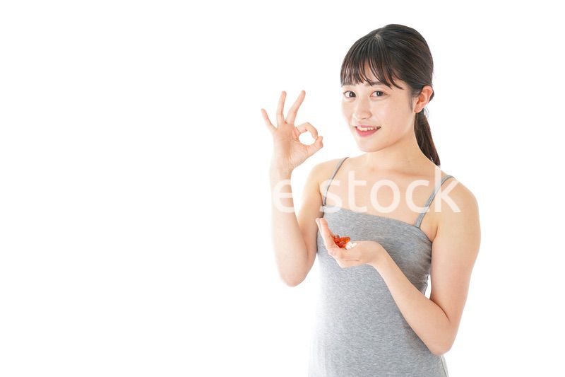 薬・サプリメントを服用する若い女性