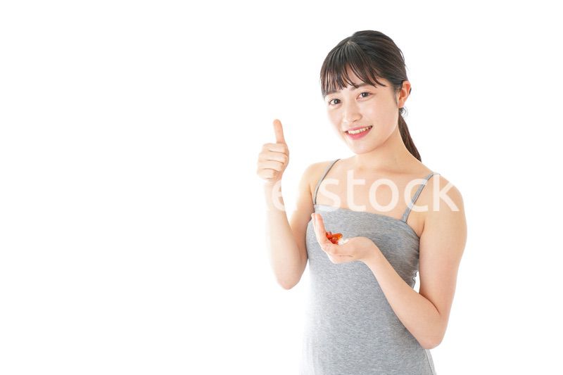 薬・サプリメントを服用する若い女性