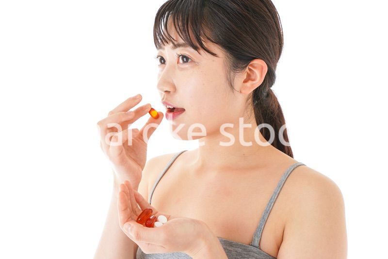 薬・サプリメントを服用する若い女性