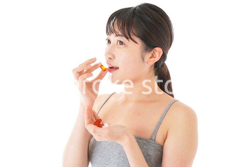 薬・サプリメントを服用する若い女性