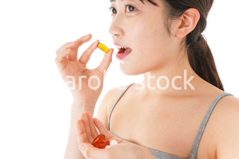 薬・サプリメントを服用する若い女性