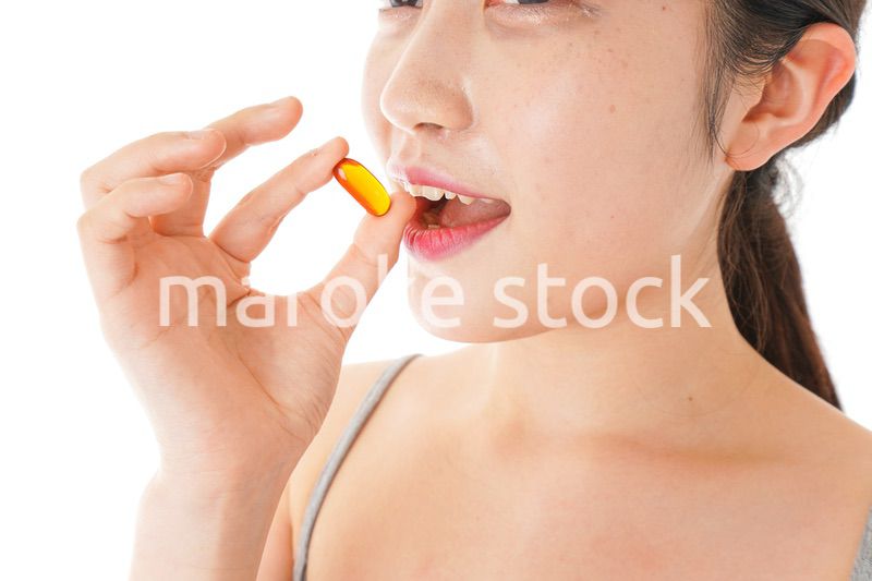 薬・サプリメントを服用する若い女性