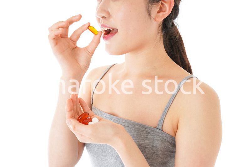 薬・サプリメントを服用する若い女性